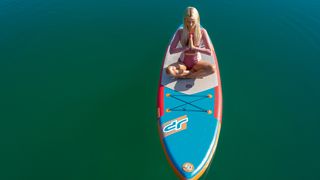 Frau auf Paddelbord auf dem See, Stand-Up-Yoga auf dem See, Tourist Information Kochel a. See