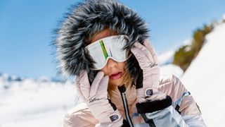 Frau mit Kapuze und Ski-Brille im Schnee, Intersport