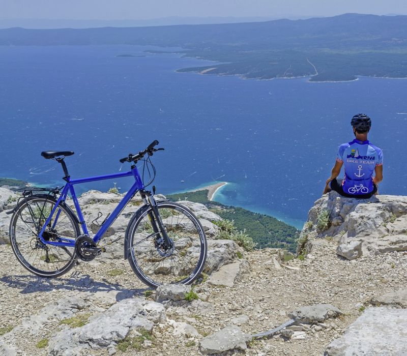 Fahrradfahrer auf Klippe mit Meeresblick, I.D. Riva Tours